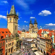Historisches Stadtzentrum mit Turm und gotischer Kirche bei blauem Himmel.