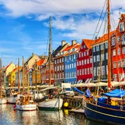Bunte Gebäude und Boote am Nyhavn in Kopenhagen bei Sonnenschein.