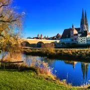 herbstliches Regensburg an der Donau in Bayern© Freesurf - stock.adobe.com Farbige Stadtansicht mit Fluss und Steinbrücke bei blauem Himmel.