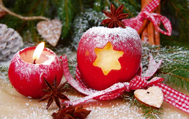 Rote Äpfel mit Sternmotiv und Anis auf weihnachtlich dekoriertem Tisch