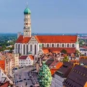Stadtansicht mit Kirche und historischen Gebäuden bei klarem Himmel.